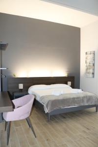 una camera con letto, scrivania e sedia di IOLETTA HOUSE a Catania