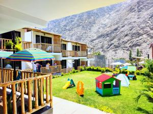 a yard with a playground with a mountain in the background at Jalara Lunahuaná Hotel in Lunahuaná