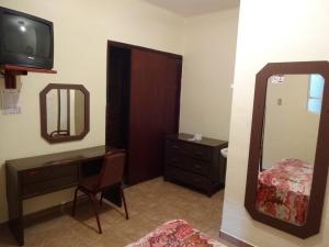 baño con espejo, tocador y TV en Hotel Del Centro, en Puebla
