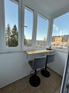 Zimmer mit Fenstern, einem Schreibtisch und einem Stuhl in der Unterkunft Apartman Winter Nights Vlašić in Vlasic