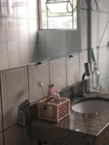 a bathroom sink with a basket on the counter at casa de Luciana - Lençóis in Lençóis