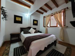 a bedroom with a bed and a window at Casa Cantabria Hotel in Villa de Leyva