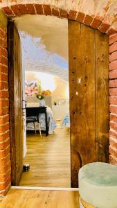 a room with a brick wall and an open door at Les Rêves d'Églantine et d'Augusta Chambres et Gîtes in Saint-Cyr