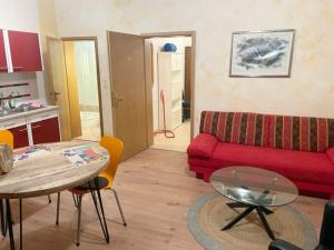 a living room with a red couch and a table at Kuckucksnest in Bielefeld