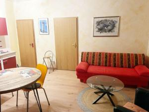 - un salon avec un canapé rouge et une table dans l'établissement Kuckucksnest, à Bielefeld