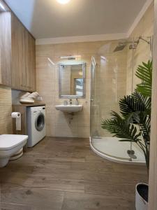a bathroom with a shower sink and a washing machine at Garbary 100 CITY CENTER Apartment, free parking, self check-in 24h in Poznań +29 photos