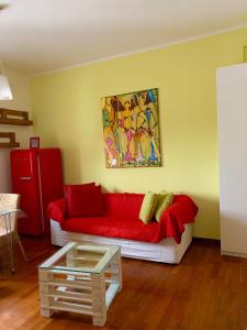 a living room with a red couch and a painting at BellAria Bliss Relax a 10 Minuti dal Cuore di Bologna con parcheggio privato in Bologna