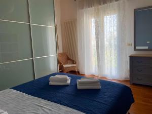 a bedroom with a bed with two towels on it at BellAria Bliss Relax a 10 Minuti dal Cuore di Bologna con parcheggio privato in Bologna