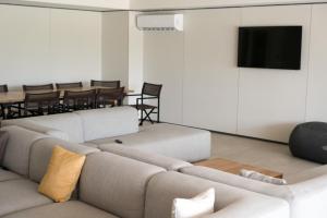 a living room with a couch and a flat screen tv at Emerald Apt at Maho Beach in Maho Reef