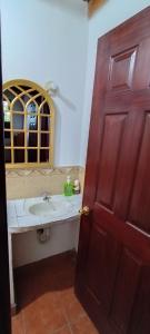 baño con lavabo y puerta de madera en Hotel Posada Don Papagon en Antigua Guatemala