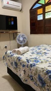 een slaapkamer met een bed, een ventilator en een tv bij casa de Luciana - Lençóis in Lençóis
