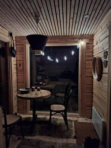 um quarto com uma mesa e cadeiras e uma janela em Wilderness Cabin Onnela em Rovaniemi