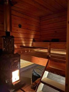 a sauna with a bench in a wooden room at Wilderness Cabin Onnela in Rovaniemi