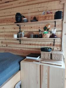 a room with a wooden wall with shelves and a table at Wilderness Cabin Onnela in Rovaniemi