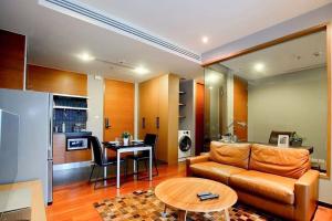a living room with a couch and a table at 5minsWalkThonglorBTS/1BR/wWorkingRM/Gym&Pool in Bangkok