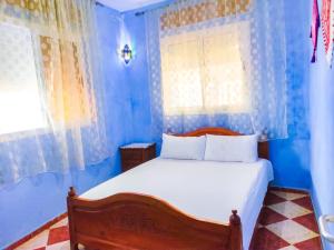 - une chambre avec des murs bleus et un lit avec des draps blancs dans l'établissement Dar Khairoun with Parasole, à Chefchaouen