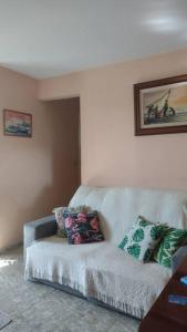 a living room with a couch with pillows on it at Quarto em apt compartilhado com estacionamento incluso in Niterói