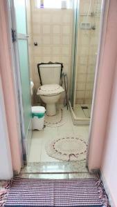 a bathroom with a toilet and a glass shower at Quarto em apt compartilhado com estacionamento incluso in Niterói