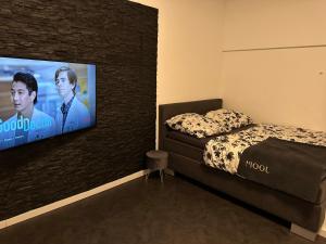Butler Suites في دوسلدورف: غرفة نوم بسرير وتلفزيون بشاشة مسطحة