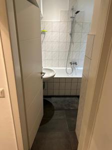 Butler Suites في دوسلدورف: حمام مع حوض وحوض استحمام