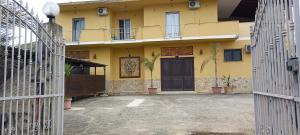 ein gelbes Haus mit einer schwarzen Tür im Innenhof in der Unterkunft Appartamento Luna D'oro in Montallegro