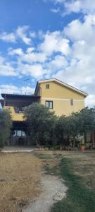 a large yellow house with trees in front of it at Appartamento Luna D'oro in Montallegro