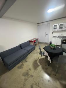ein Wohnzimmer mit einem Sofa und einem Tisch in der Unterkunft Apartamento para grupos grandes dentro de centro comercial con frisby in Cartago