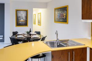 a kitchen with a sink and a table with chairs at Modern Central 2BR Flat in Valletta in Valletta