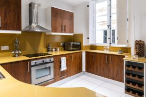 a kitchen with wooden cabinets and a stove top oven at Modern Central 2BR Flat in Valletta by Arco Collection in Valletta