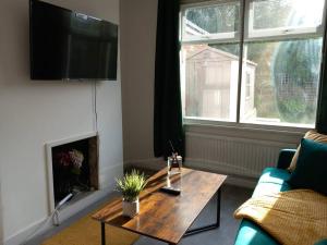 Affordable Home in Hatfield في هاتفيلد: غرفة معيشة مع طاولة قهوة ومدفأة