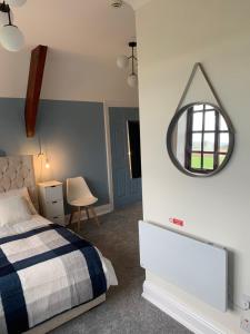 a bedroom with a bed and a mirror on the wall at The Vicarage in Sunderland
