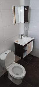 a bathroom with a white toilet and a sink at Casa Atlántida 2 Dorm. Deck con Parrillero, 3 de Playa Mansa in Atlántida
