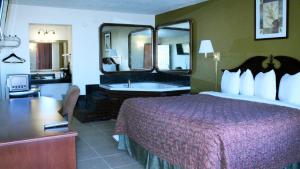 een hotelkamer met een groot bed en een badkamer bij Royal Inn & Suites in Tyler