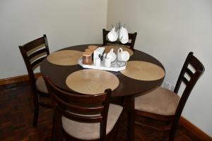 een eettafel met 4 stoelen en een houten tafel bij Stawi Apartment in Nairobi