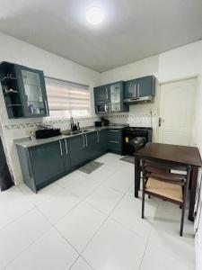 une cuisine avec des placards verts et une table. dans l'établissement Schimmelpenninck Paramaribo Villa, à Paramaribo