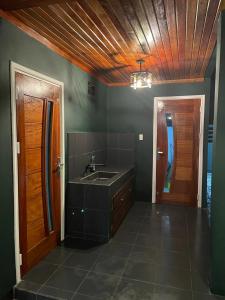 Il comprend une cuisine avec un évier et un plafond en bois. dans l'établissement Schimmelpenninck Paramaribo Villa, à Paramaribo