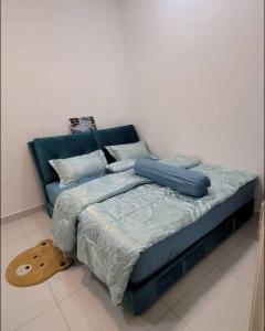 a bed with blue sheets and pillows in a room at Lee Batu Ferringhi Condominium in Batu Ferringhi