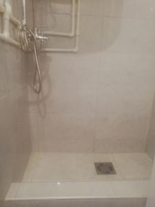 a bathroom with a shower with a drain at Apartman Ivana in Užice