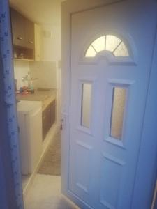 a white door with a window in a kitchen at Apartman Ivana in Užice