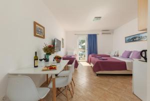 un salon avec un lit, une table et des chaises dans l'établissement Villa Mia Apartments, à Bijela 96 autres photos