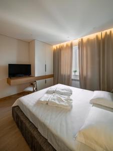um quarto com uma grande cama branca e uma secretária em Deluxe Apartment em Tashkent
