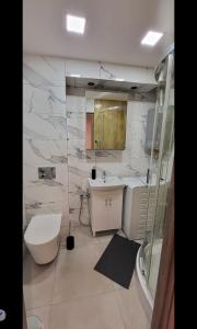 a bathroom with a toilet and a sink at Apartament Przemyślany in Przemyśl +19 photos