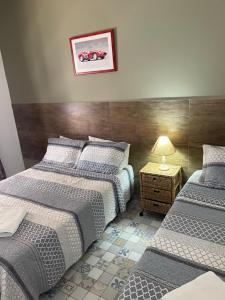 1 dormitorio con 2 camas y mesa con lámpara en Villa Di Verona Charm Hotel, en Guarujá