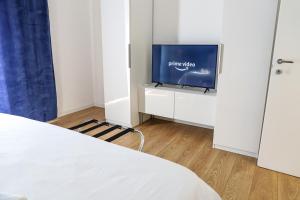 ein Schlafzimmer mit einem TV in einem weißen Zimmer in der Unterkunft Concept Apartment in Belpasso