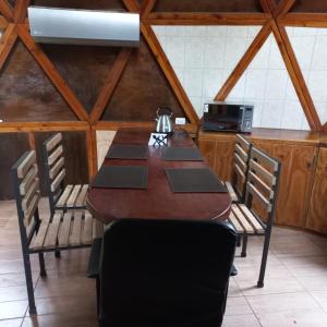 a dining room with a table and chairs in a kitchen at Domo Geodésico Las Burritas in Osorno