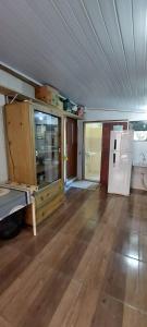 an empty room with a kitchen and a refrigerator at Suíte o Pescador, praia do rosa in Garopaba