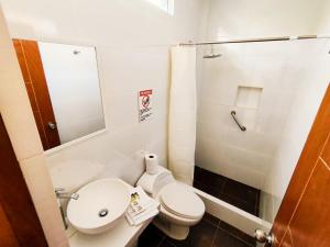 a bathroom with a toilet and a sink and a shower at Jalara Lunahuaná Hotel in Lunahuaná