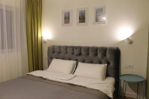 uma cama com uma cabeceira acolchoada cinzenta num quarto em "Dad and Daughter Weekend House" em Rūdaičiai