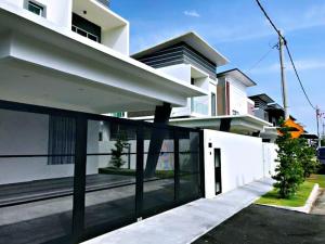 une grande maison blanche avec une clôture devant elle dans l'établissement G-Homestay @ Sungai Abong Muar*10~20pax, à Muar