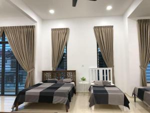 - une chambre avec 2 lits dans une pièce avec fenêtres dans l'établissement G-Homestay @ Sungai Abong Muar*10~20pax, à Muar